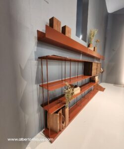 Libreria in metallo color terra cotta con dettagli in legno, esposta al Salone del Mobile.